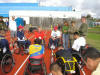 Disabled veterans huddle around to pick up some pointers from experienced wheelchair racers.